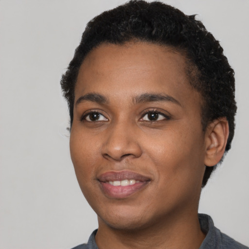 Joyful black young-adult female with short  black hair and brown eyes