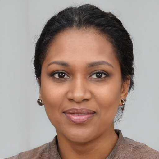 Joyful black young-adult female with medium  black hair and brown eyes