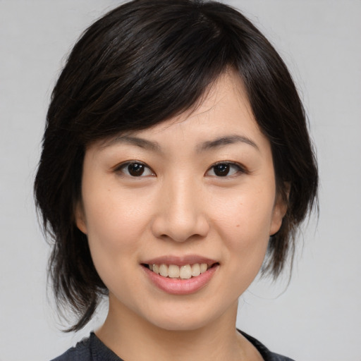 Joyful asian young-adult female with medium  brown hair and brown eyes