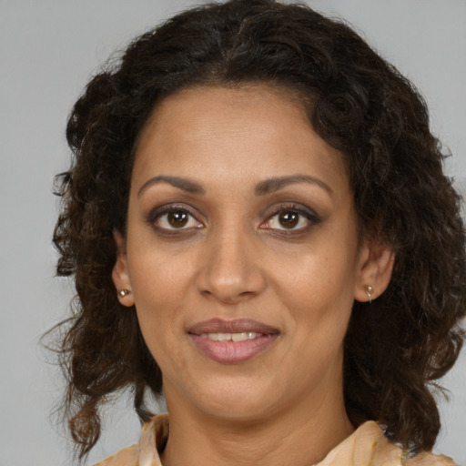 Joyful black adult female with medium  brown hair and brown eyes