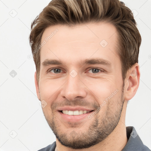 Joyful white young-adult male with short  brown hair and grey eyes