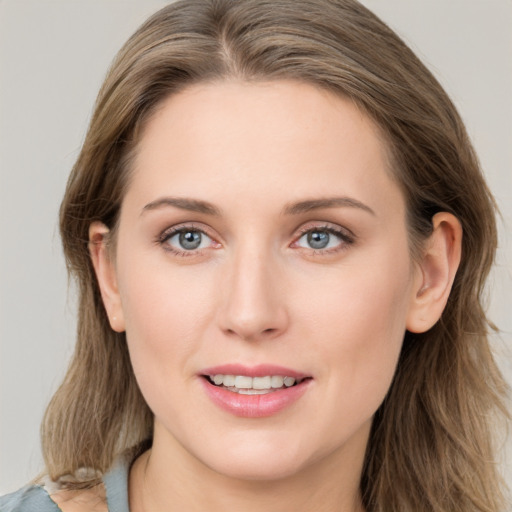 Joyful white young-adult female with long  brown hair and blue eyes