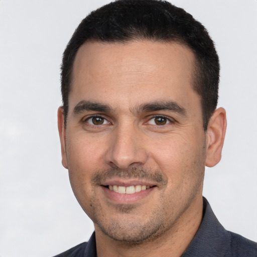 Joyful white young-adult male with short  black hair and brown eyes