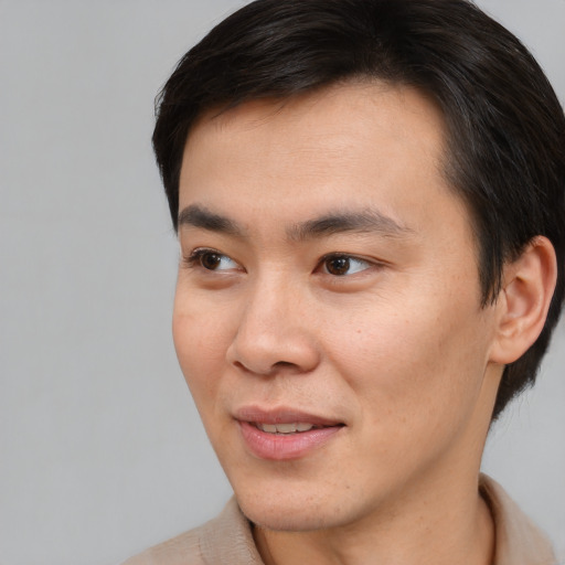 Joyful asian young-adult male with short  brown hair and brown eyes