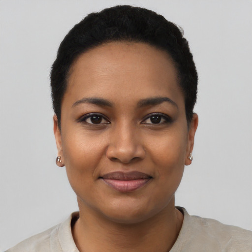 Joyful black young-adult female with short  black hair and brown eyes