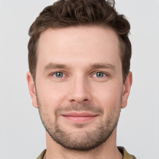 Joyful white young-adult male with short  brown hair and grey eyes