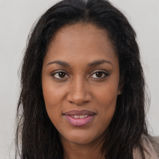Joyful black young-adult female with long  brown hair and brown eyes