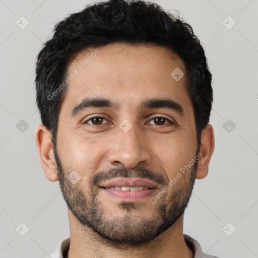 Joyful latino young-adult male with short  black hair and brown eyes