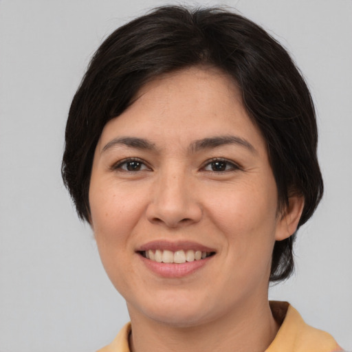 Joyful asian adult female with medium  brown hair and brown eyes