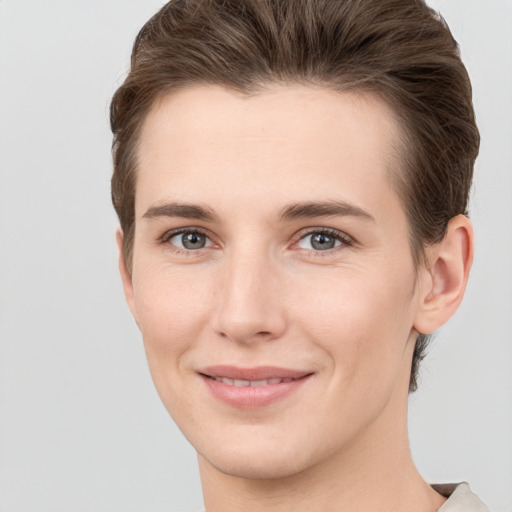 Joyful white young-adult female with short  brown hair and grey eyes