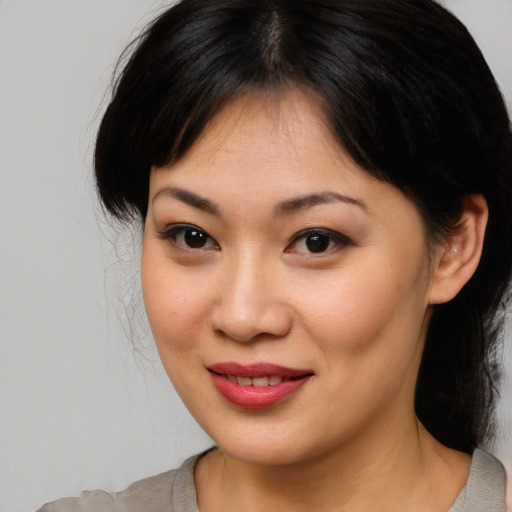 Joyful asian young-adult female with medium  brown hair and brown eyes