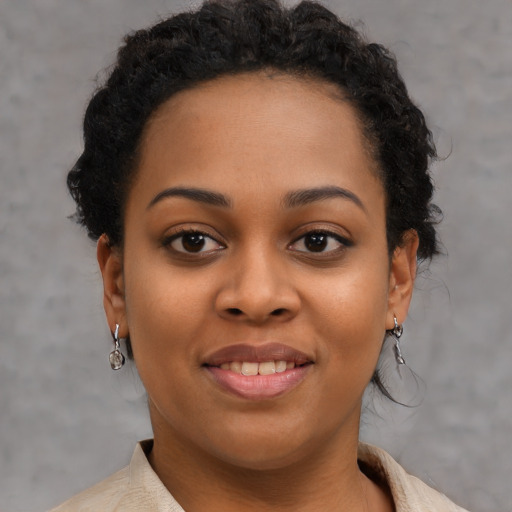 Joyful black young-adult female with short  brown hair and brown eyes