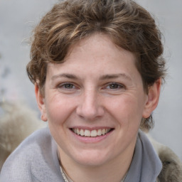 Joyful white young-adult female with short  brown hair and blue eyes