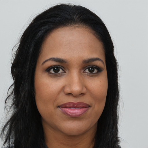 Joyful black young-adult female with long  brown hair and brown eyes