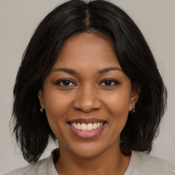 Joyful black young-adult female with medium  brown hair and brown eyes