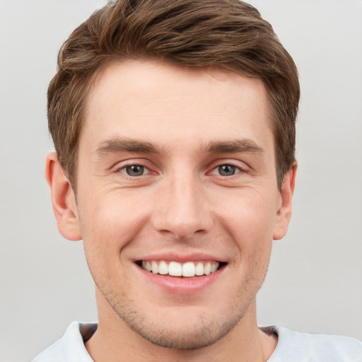 Joyful white young-adult male with short  brown hair and grey eyes