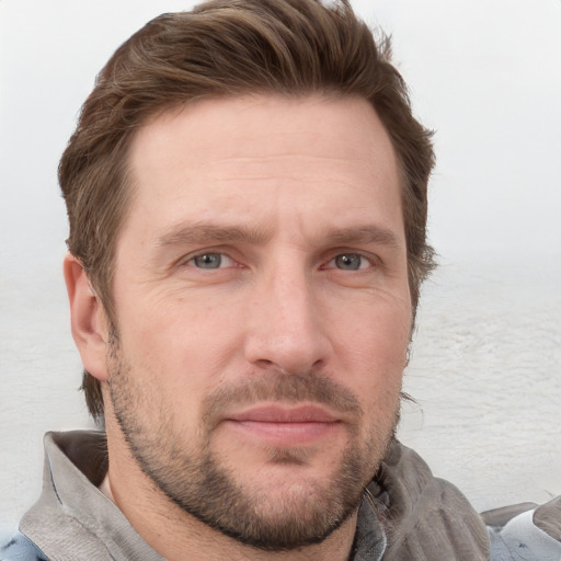 Joyful white adult male with short  brown hair and blue eyes