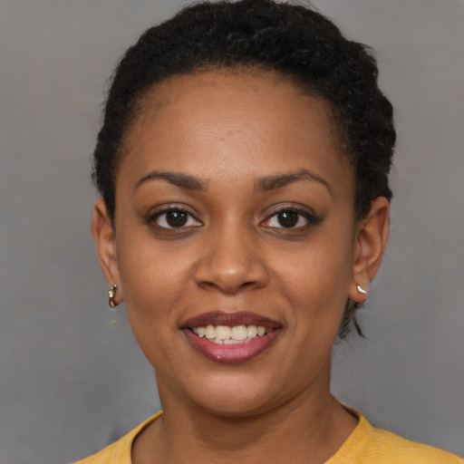 Joyful black young-adult female with short  brown hair and brown eyes