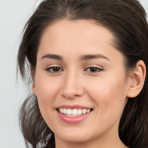 Joyful white young-adult female with long  brown hair and brown eyes