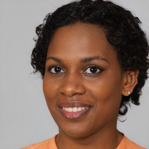 Joyful black young-adult female with medium  black hair and brown eyes