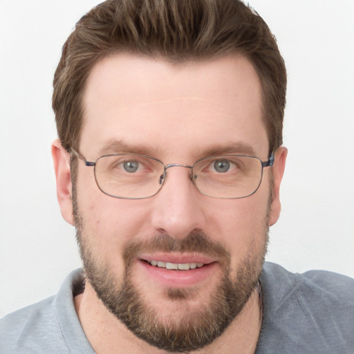 Joyful white adult male with short  brown hair and blue eyes