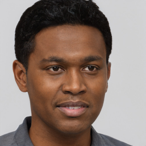 Joyful black young-adult male with short  black hair and brown eyes
