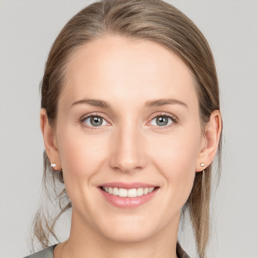 Joyful white young-adult female with medium  brown hair and blue eyes