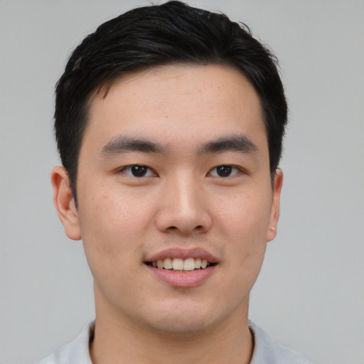 Joyful asian young-adult male with short  black hair and brown eyes