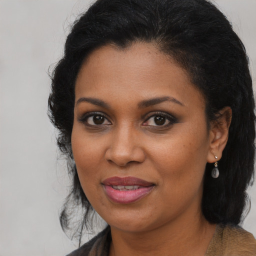 Joyful black adult female with long  brown hair and brown eyes