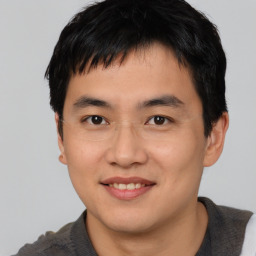 Joyful asian young-adult male with short  black hair and brown eyes