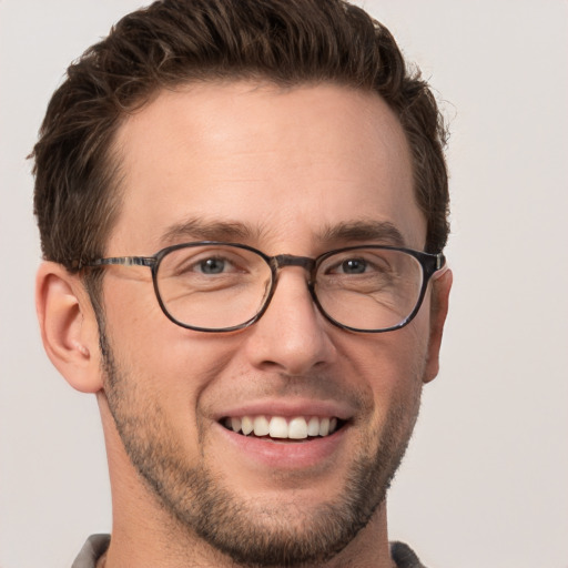 Joyful white young-adult male with short  brown hair and grey eyes