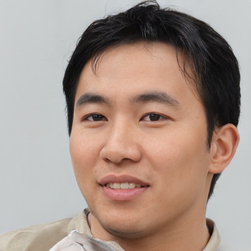 Joyful asian young-adult male with short  black hair and brown eyes