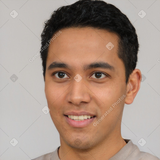 Joyful latino young-adult male with short  black hair and brown eyes