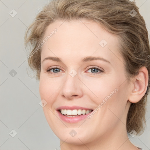 Joyful white young-adult female with medium  brown hair and blue eyes