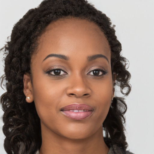 Joyful black young-adult female with long  brown hair and brown eyes