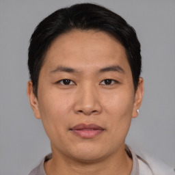 Joyful asian adult male with short  black hair and brown eyes