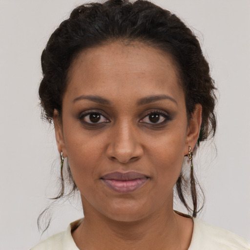 Joyful black young-adult female with medium  brown hair and brown eyes