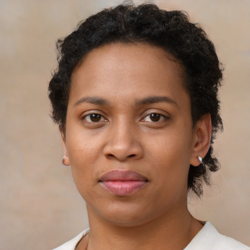 Joyful black young-adult female with short  brown hair and brown eyes