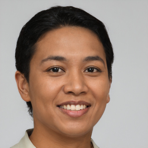 Joyful latino young-adult female with short  black hair and brown eyes