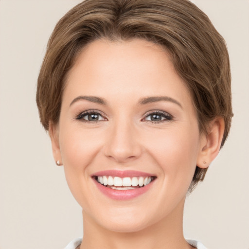 Joyful white young-adult female with medium  brown hair and green eyes