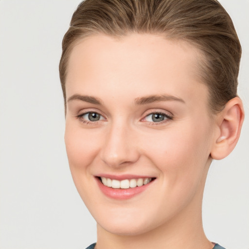 Joyful white young-adult female with short  brown hair and grey eyes