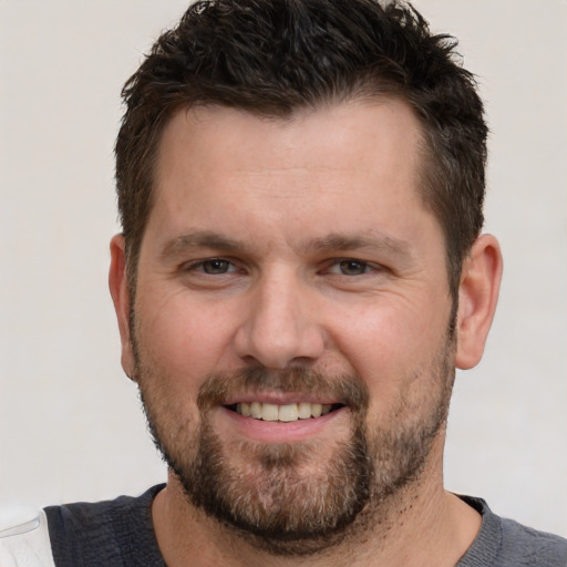 Joyful white adult male with short  brown hair and brown eyes