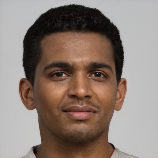 Joyful black young-adult male with short  black hair and brown eyes