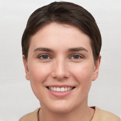 Joyful white young-adult female with short  brown hair and grey eyes