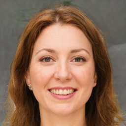 Joyful white young-adult female with long  brown hair and green eyes