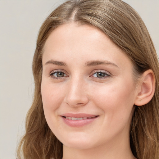 Joyful white young-adult female with long  brown hair and blue eyes