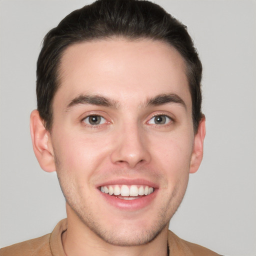 Joyful white young-adult male with short  brown hair and grey eyes