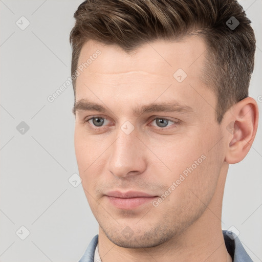 Joyful white young-adult male with short  brown hair and grey eyes