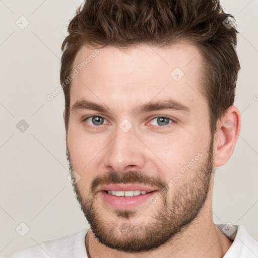 Joyful white young-adult male with short  brown hair and brown eyes