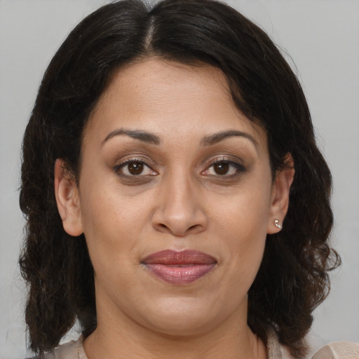 Joyful latino adult female with medium  brown hair and brown eyes